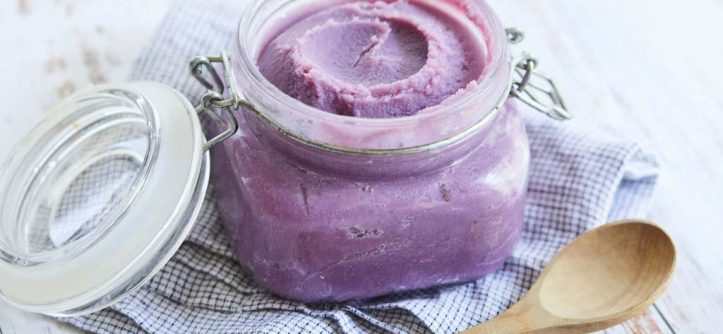 Creamy vibrant purple Ube Halaya in a glass jar with wooden spoon beside it, natural lighting