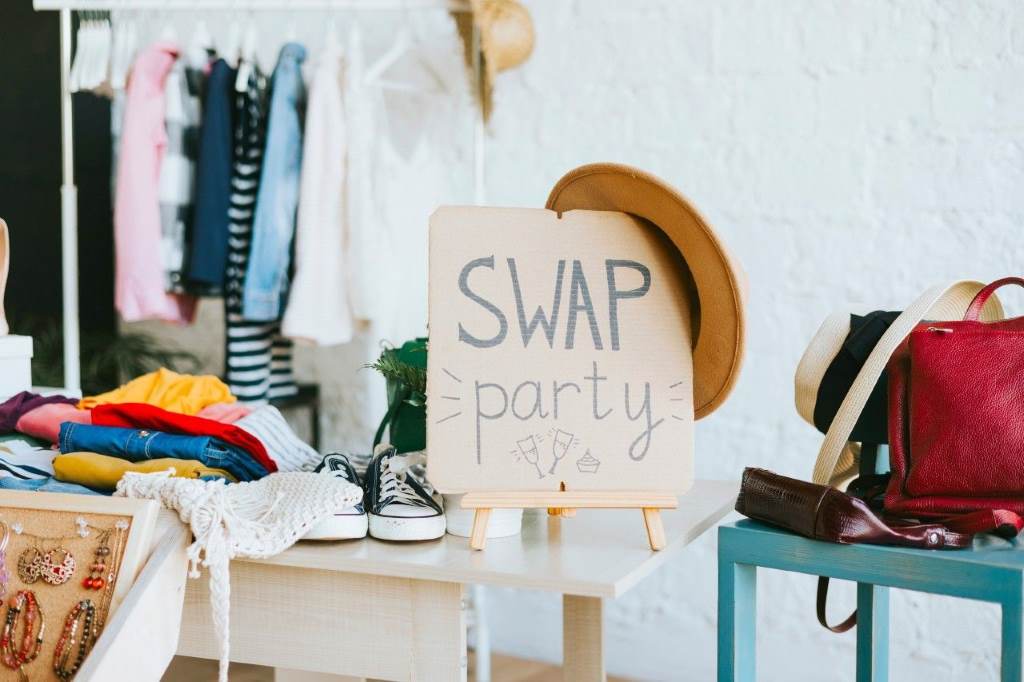 Smiling guests trying on high-waisted skirts and geometric print tops in a cozy dressing room