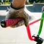 Rider hands holding patterned BMX grips on handlebars during a jump.