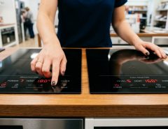 Person cooking on a modern induction cooktop in a Western Australian kitchen.