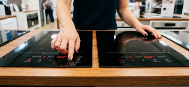 Person cooking on a modern induction cooktop in a Western Australian kitchen.