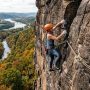 A rock climber scaling a cliff using a colorful dynamic climbing rope in Pennsylvania.