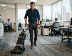 A man using a commercial vacuum in a Texas office.