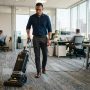 A man using a commercial vacuum in a Texas office.