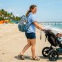 Parent carrying a durable diaper backpack on a sunny Florida beach. (9 words)