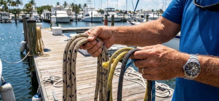 A coiled marine anchor rope sitting on a wooden boat deck in Florida.