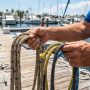 A coiled marine anchor rope sitting on a wooden boat deck in Florida.