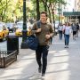 Man walking down urban street carrying lightweight sports bag