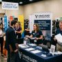 Cleared job seekers talking with recruiters at a Chantilly career fair booth